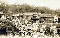 関帝廟改修25周年関帝誕の祭日、前田橋を渡る龍舞行列　1910年7月　当館蔵絵はがき